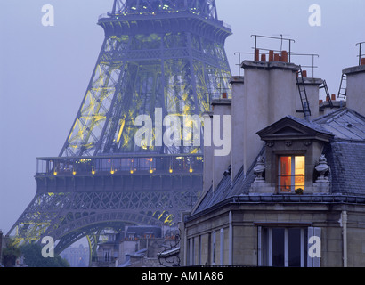 Luce calda proveniente da appartamento finestra sotto la Torre Eiffel Foto Stock