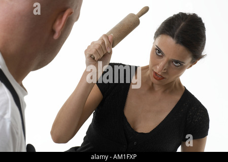 La donna è minacciare un uomo con un mattarello Foto Stock