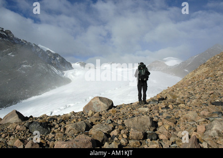 Alpinista in piedi su massi nella parte anteriore di un ghiacciaio Kharkhiraa Altai mongolo vicino Ulaangom Uvs Aymag Mongolia Foto Stock
