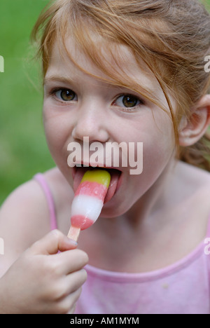 Bambina a mangiare il gelato ghiacciato per lecca-lecca Foto Stock