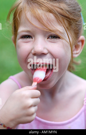 Bambina a mangiare il gelato ghiacciato per lecca-lecca Foto Stock