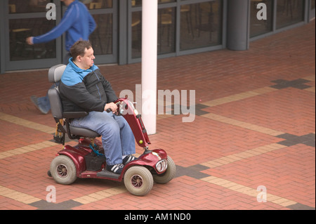 Un uomo disabili su uno scooter di mobilità in Burnley shopping center Lancashire Foto Stock