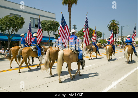 I cowboys marciando con bandierine americane visualizzato durante il giorno di apertura parade down Street Santa Barbara CA vecchi giorni di spagnolo Foto Stock