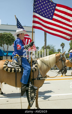 I cowboys marciando con bandierine americane visualizzato durante il giorno di apertura parade down Street Santa Barbara CA vecchi giorni di spagnolo Foto Stock