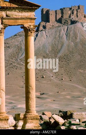 Le antiche rovine romane di Palmyra in Siria e Qalaat Ibn Maan castello musulmano in background Foto Stock