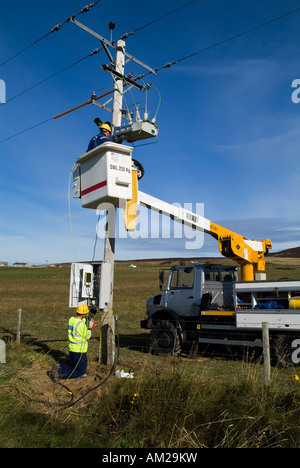 dh Hydro Electric ELETTRICITa' operai UK che lavorano su linee elettriche a poli di alimentazione Orkney rete sollevamento lavoro idroelettrico culla lavoratori nazionali Foto Stock