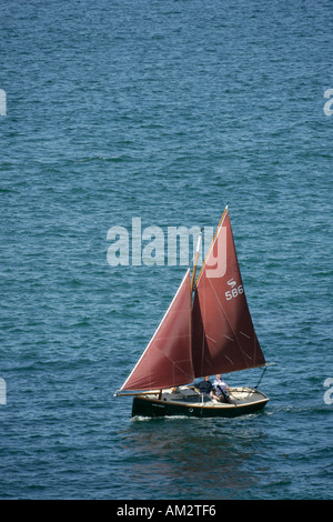 Un cornish crabbber vele al di fuori della baia di Damar Cornwall a Ferragosto Foto Stock