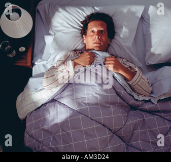 L'uomo sveglio nel letto non dorme, preoccupato insomniac Foto Stock