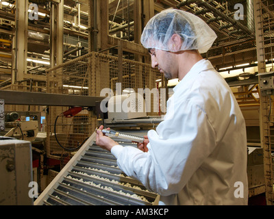 L'uomo controllare le dimensioni delle mentos durante la produzione della caramella nella fabbrica di Breda Paesi Bassi Foto Stock