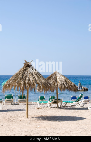 Due palm ombrelloni sulla spiaggia di sabbia bianca a Cala Moli, Ibiza Foto Stock