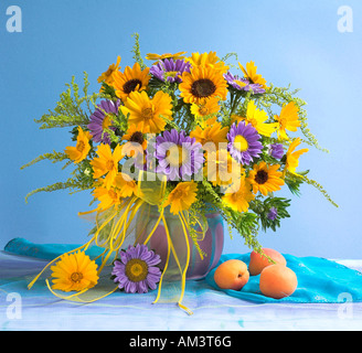 Studio disposti mazzetto bouquet di giallo dei girasoli in un vaso su un pastello sfondo blu Foto Stock