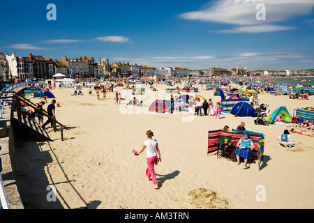 La gente a prendere il sole sulla spiaggia di Weymouth in estate, Dorset, England, Regno Unito Foto Stock