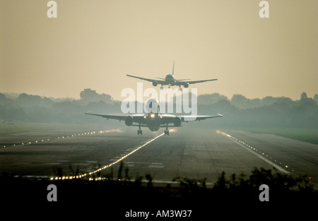 Un getto prende il largo come un altro viene a terra all'aeroporto di Londra Gatwick all'alba Foto Stock