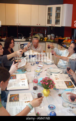 Famiglia intorno alla tradizionale tabella sedder impostato per una festa ebraica pasto sulla Pasqua Foto Stock