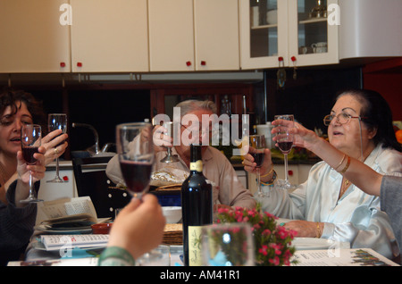 Famiglia intorno alla tradizionale tabella sedder impostato per una festa ebraica pasto sulla Pasqua Foto Stock