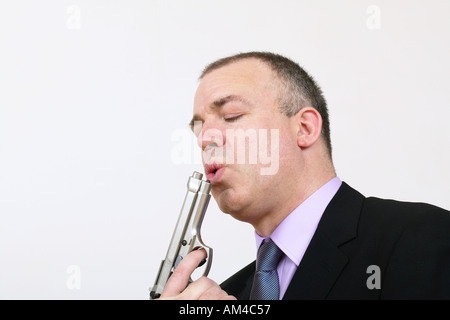 Uomo in tuta soffia sulla pistola a mano Foto Stock