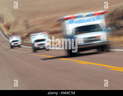 Tre le ambulanze correre verso il basso di una autostrada Foto Stock