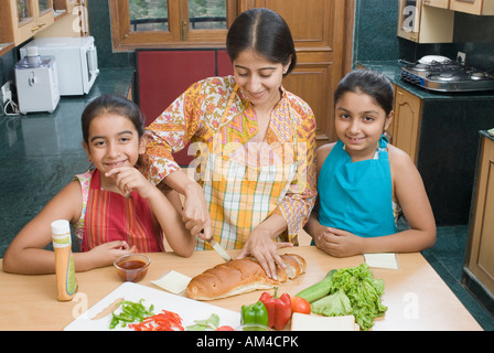 Close-up di una metà donna adulta rendendo i panini con le sue figlie Foto Stock