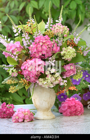 Disposta verticale colorata mazzetto bouquet di rosa in fiore i fiori delle ortensie in giardino Foto Stock