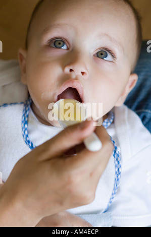 Close-up di mano di una persona di alimentazione per alimentare un bambino Foto Stock