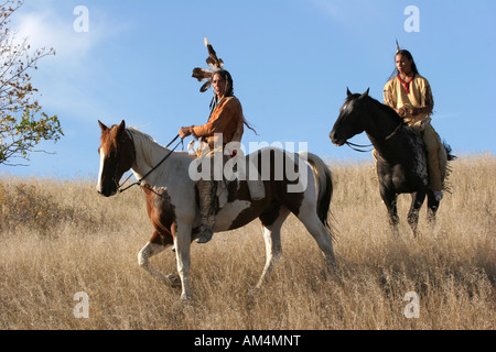 Due nativi indiani americani gli uomini a cavallo scouting per i nemici o a caccia di cibo nella prateria del Dakota del Sud Foto Stock