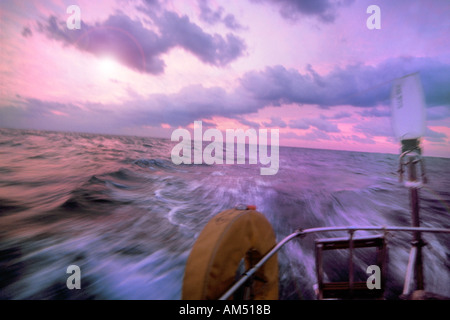 Guardando fuori a poppavia dal cockpit di barca a vela in corso su un blu passaggio di acqua Foto Stock