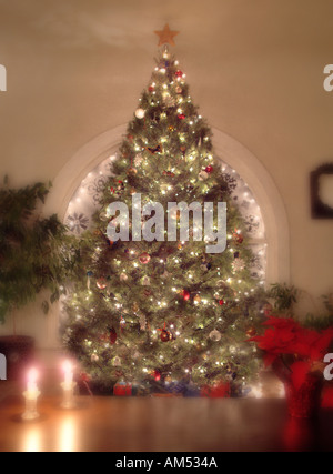 Un grande e decorata e albero di Natale illuminato nel salotto di casa. Foto Stock