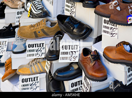 Vendita. Tutti i tipi di scarpe a buon mercato in una vetrina di un centro di outlet in Buenos Aires. Prezzi in peso argentino; segni in spagnolo. Foto Stock