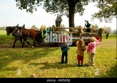 Tre bambini sventolando, Leonhardifahrt in Thambach, Alta Baviera, Baviera, Germania Foto Stock