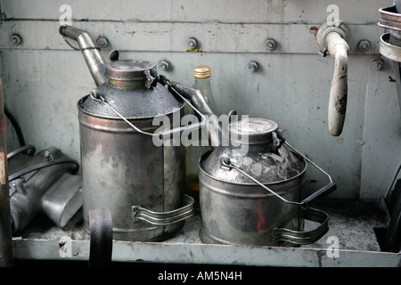 Due vecchie lattine di olio in uno storico treno a vapore Foto Stock