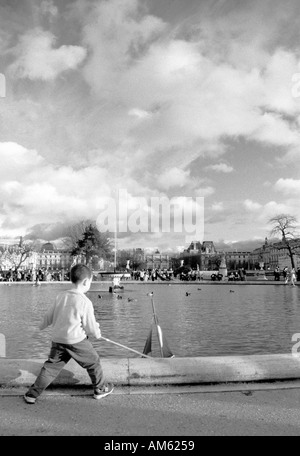 Ragazzo giocando con la barca Jardin des Tuileries, Parigi, Francia Foto Stock