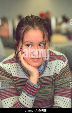 Triste Asian teen girl età 18 in attesa presso Minneapolis-St. Paul International Airport. Minneapolis Minnesota USA Foto Stock