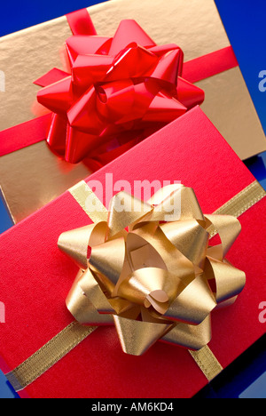 Gold confezione regalo con un nastro rosso e la casella rossa con la prua in oro Foto Stock