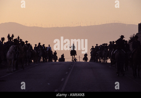 Tarifa la processione annuale di cavalieri che si tiene in onore di La Virgen de la Luz entra nel borgo al tramonto Foto Stock