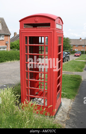 Un fracassato e soggetto ad atti vandalici telefono rosso scatola su un consiglio estate in Highworth Wiltshire Foto Stock