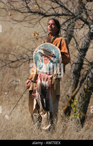 Un Native American Indian uomo in piedi con un'arma con uno scudo Foto Stock