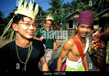 Kalimantan turisti ballando con Dayak tribali nei costumi tradizionali Foto Stock