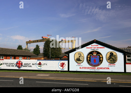 Parete luminosa dipinta Ulster Defence Association murales su Newtownards Road con il famoso giallo Harland e Wolff gru Belfast NI Foto Stock