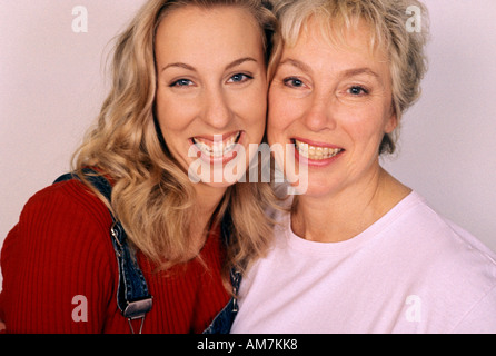 La madre abbraccia la figlia, sorridente, ritratto Foto Stock