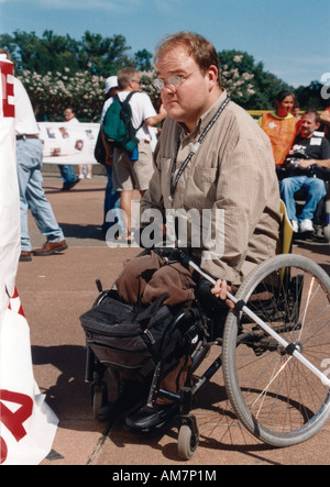 Uomo con una disabilità che utilizza una sedia a rotelle per la mobilità che frequentano un national Disability Advocacy event Foto Stock