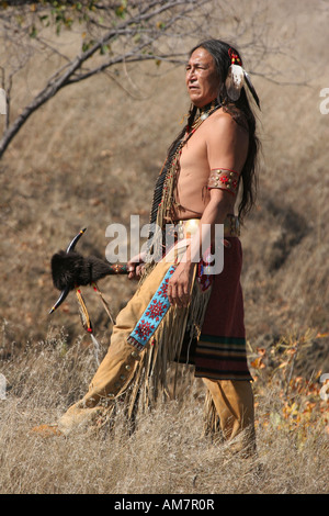 Un Native American Indian uomo in piedi con un'arma con corna Foto Stock