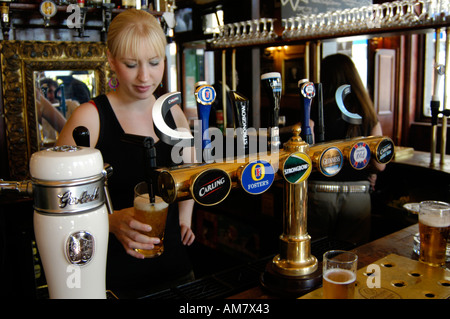 Pub barista versando una pinta di Lager in pub, Camden Town, Londra Inghilterra REGNO UNITO Foto Stock