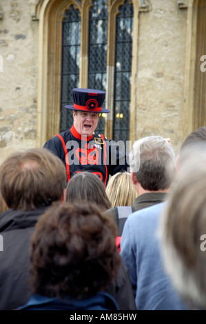 Un Beefeater risolve una folla di turisti alla Torre di Londra Foto Stock