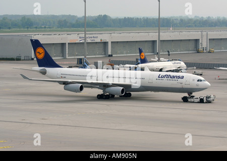 Lufthansa Airbus A340-300 passeggero aereo a getto sotto il traino all'aeroporto di Monaco di Baviera Foto Stock