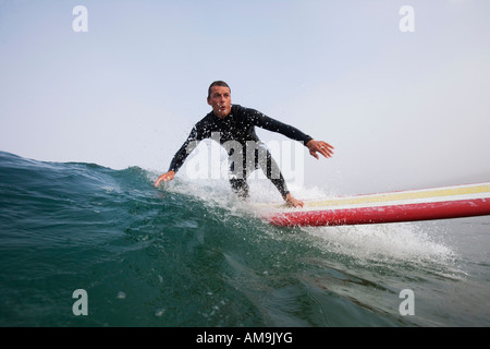 Uomo navigare un'onda. Foto Stock