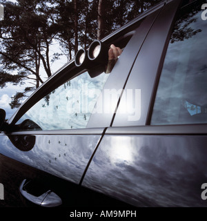 L'uomo con il binocolo spiata attraverso la finestra auto. Foto Stock