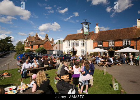 Regno Unito West Sussex Wisborough Green bevitori al di fuori del villaggio Il Cricketers Pub nella luce del sole Foto Stock