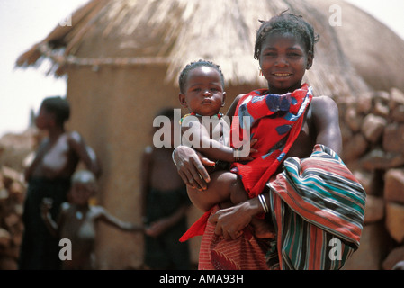 Una giovane madre mentre tiene il suo bambino in un villaggio del Mali in Africa Foto Stock