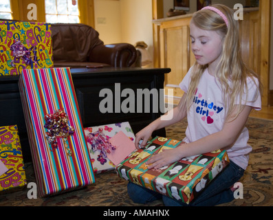 Bambino apertura di un regalo di compleanno con gli occhi chiusi Foto Stock