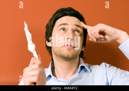 Giovane uomo puntando con il dito sulla testa Foto Stock